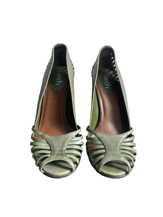 Pair of green high-heeled shoes on a white background.
