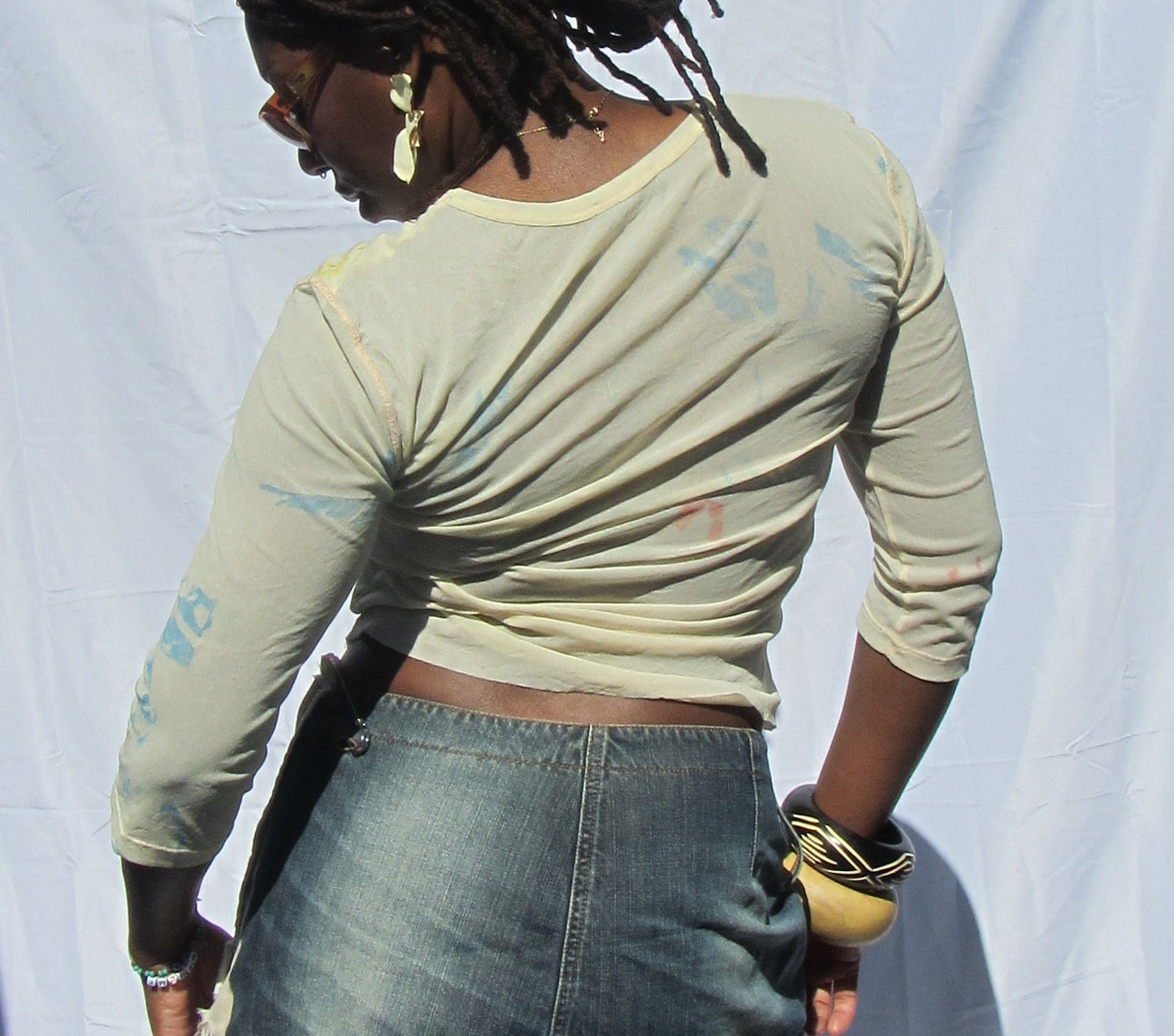 Person standing in front of a white sheet outdoors with a dark background