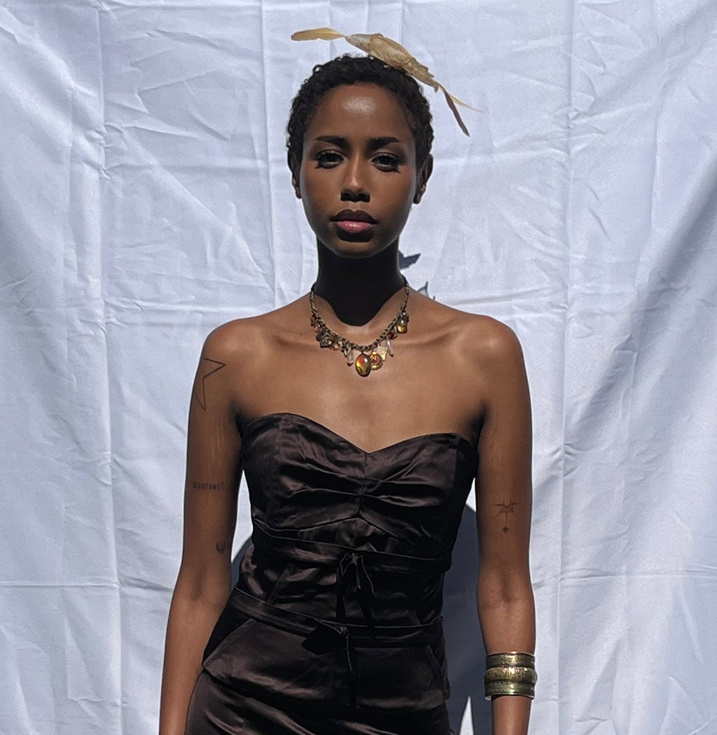 Woman wearing a dark brown crop top on a white background