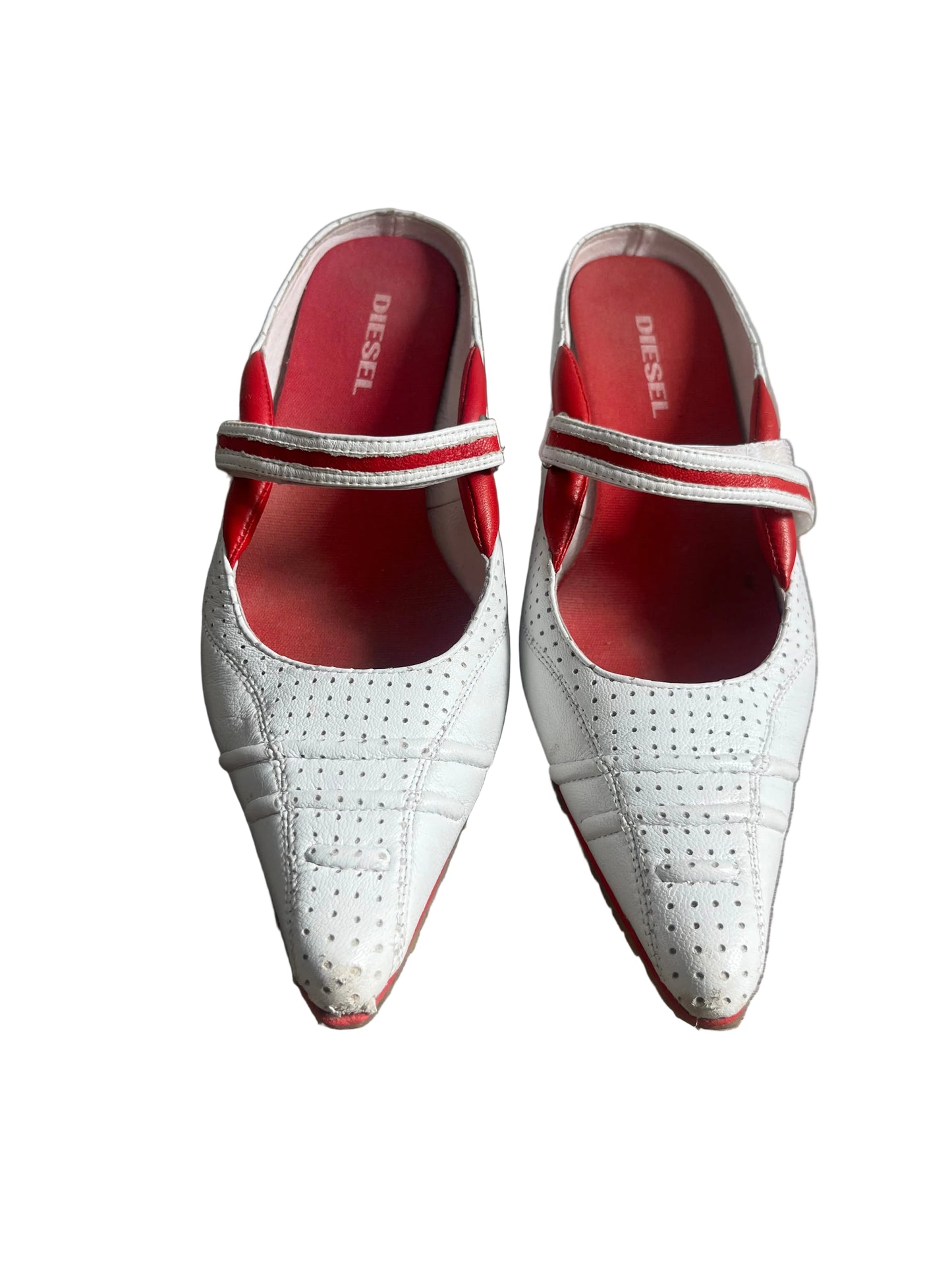White pointed-toe shoes with red soles on a white background