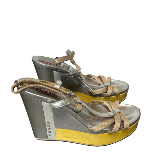 Pair of Prada wedge sandals with yellow soles on a white background