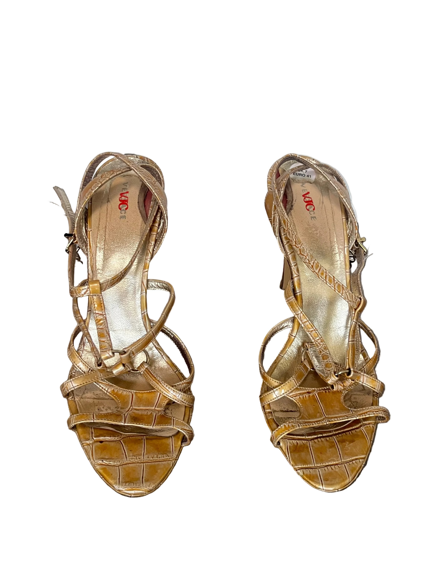 Pair of gold high-heeled sandals on a white background